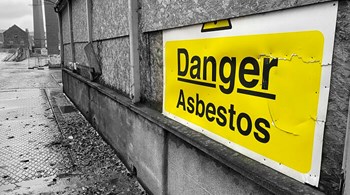 Asbestos danger sign at building construction site refurbishment of old building uk.jpg